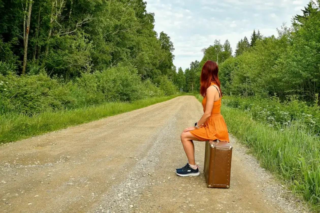 Lady with suitcase on gravel road in Kolga. Estonia slow travel -- Azzurytt Quiet Elite