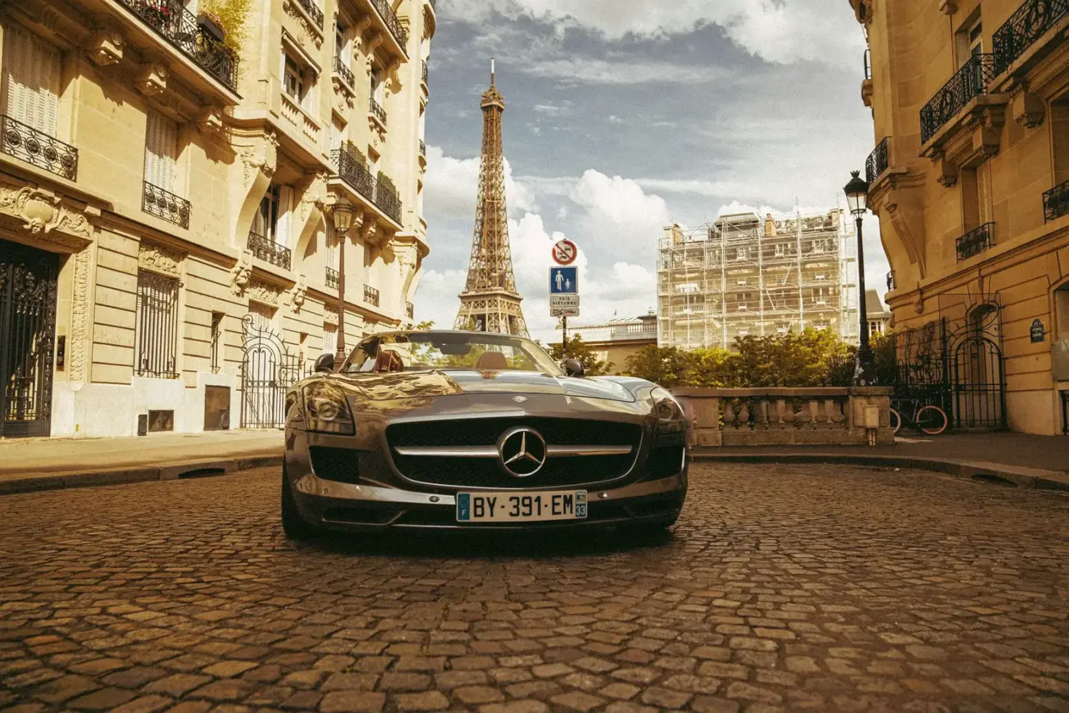 Silver Mercedes-Benz parked on a Parisian cobblestone street. Luxury Private Chauffeur in France — Azzurytt Elite Motion